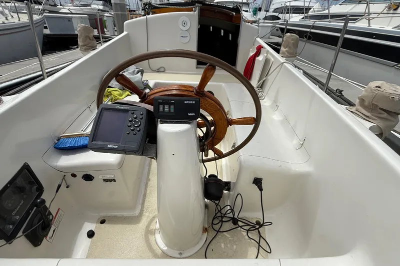 Slide: The Image of 1957 Rhodes Bounty sailboat cockpit with wooden steering wheel and navigation equipment. - 10