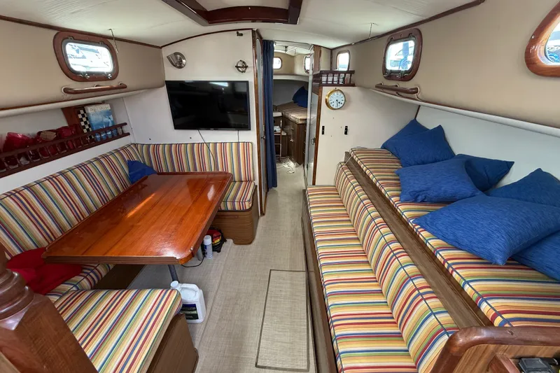 Slide: The Image of Interior of a 1957 Rhodes Bounty boat with striped seating and wooden table. - 12