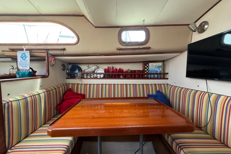 Slide: The Image of 1957 Rhodes Bounty yacht interior with striped seating, wooden table, and wall-mounted TV. - 14