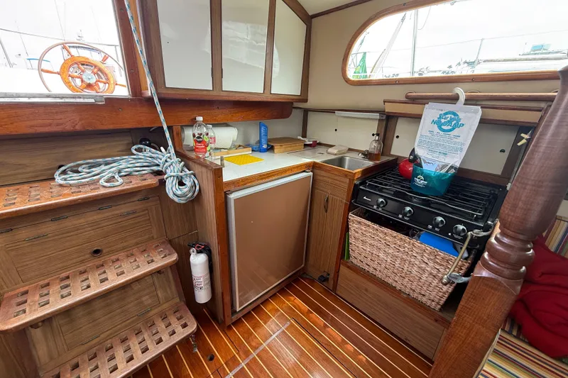 Slide: The Image of 1957 Rhodes Bounty yacht interior with wooden cabinetry, stove, and compact kitchen area. - 16