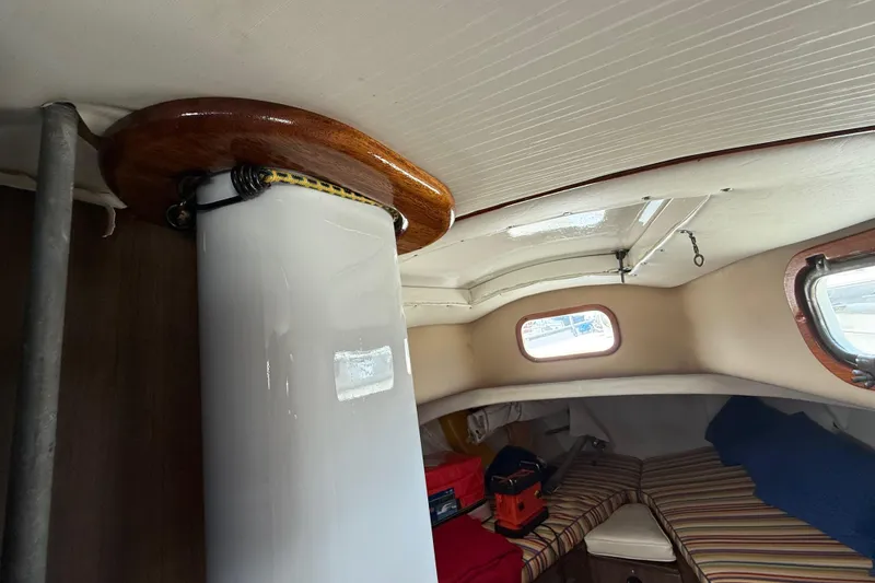 Slide: The Image of Interior of a 1957 Rhodes Bounty sailboat cabin with striped cushions and wooden accents. - 20