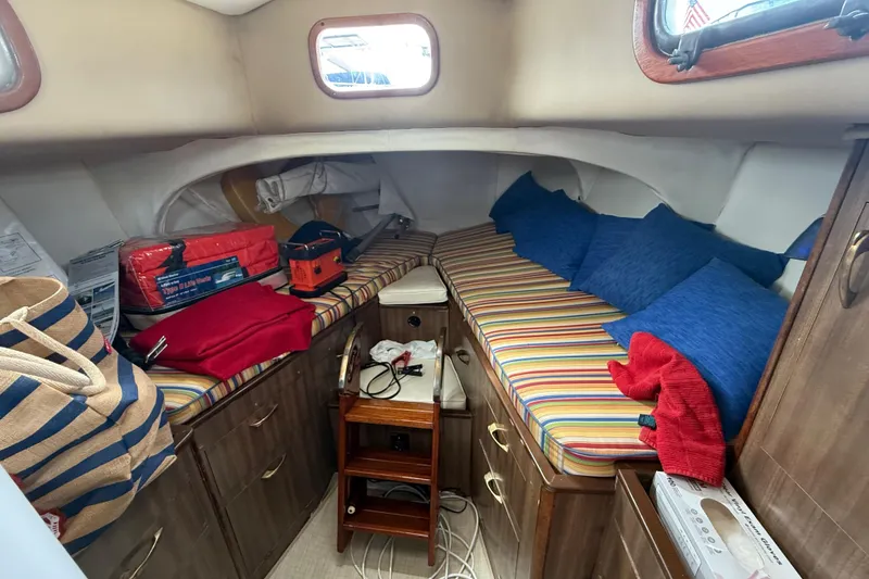 Slide: The Image of Cozy cabin interior of a 1957 Rhodes Bounty boat with striped cushions and storage. - 21