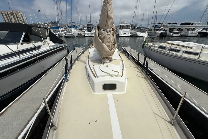 Slide: The Image of 1957 Rhodes Bounty sailboat docked at a marina, surrounded by other boats. - 6