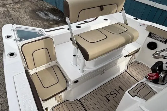 Slide: The Image of 2026 Yamaha Boats 222 FSH Sport E interior with beige seating and FSH-branded flooring. - 10