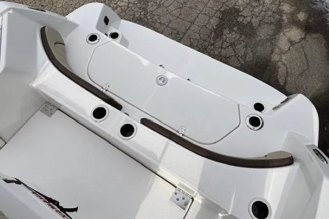 Slide: The Image of 2026 Yamaha Boats 222 FSH Sport E, white deck with cup holders and storage compartments. - 16