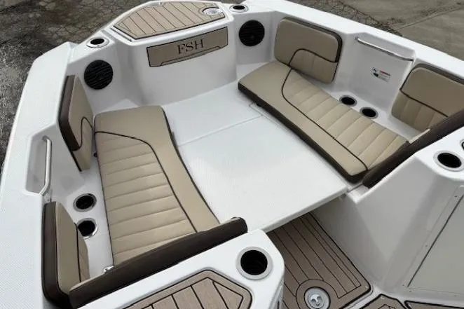 Slide: The Image of 2026 Yamaha Boats 222 FSH Sport E interior with beige seating and cup holders. - 7