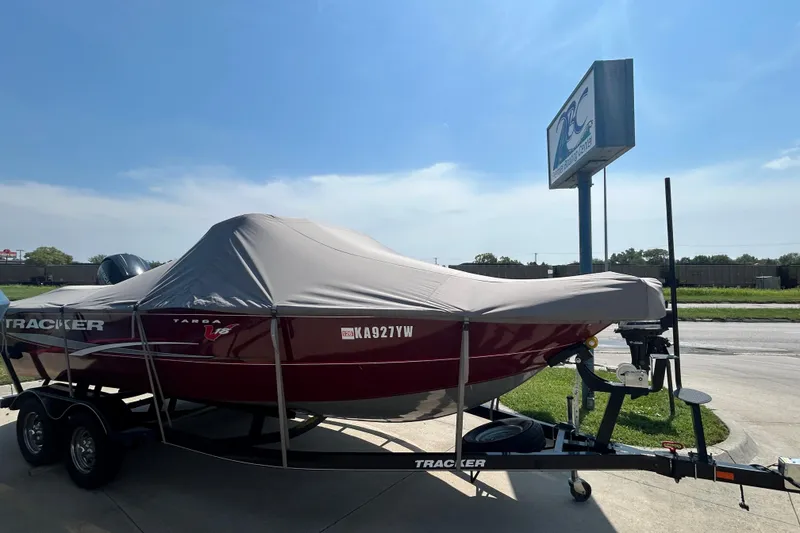 Slide: The Image of 2016 Tracker Targa V-18 Combo boat covered on trailer, parked outdoors. - 12