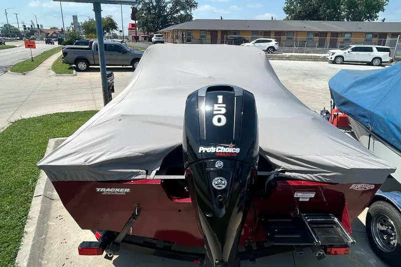 Slide: The Image of 2016 Tracker Targa V-18 Combo boat with cover and 150 HP engine in parking lot. - 8