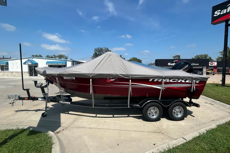 Slide: The Image of 2016 Tracker Targa V-18 Combo boat with cover on trailer, parked outdoors. - 9