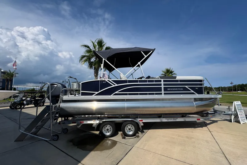 Slide: The Image of 2026 Bennington 22 SSB pontoon boat on trailer, parked outdoors under a clear sky. - 10