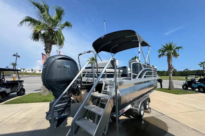 Slide: The Image of 2026 Bennington 22 SSB pontoon boat with Yamaha engine, parked near palm trees. - 12
