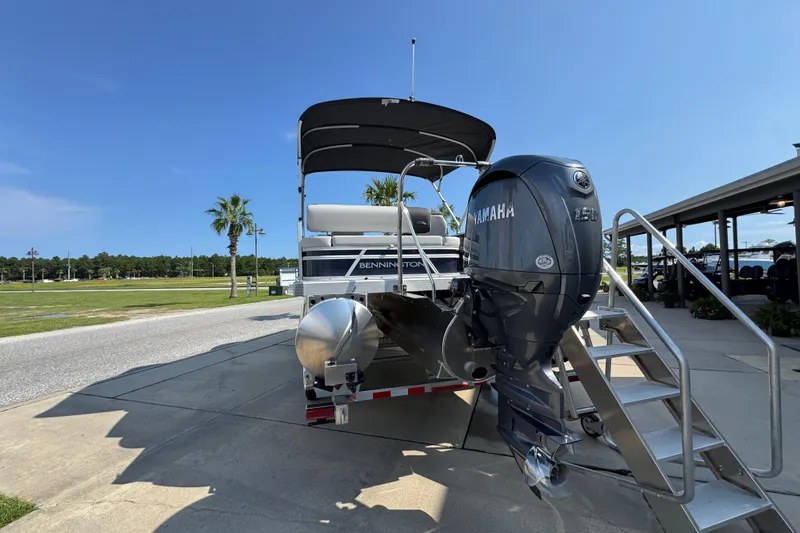 Slide: The Image of 2026 Bennington 22 SSB pontoon boat with Yamaha outboard motor, parked outdoors. - 15