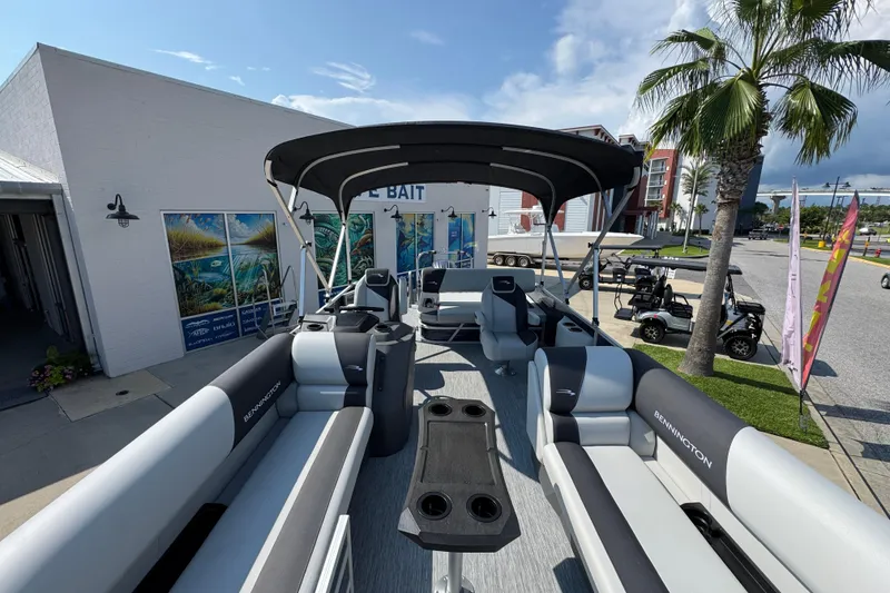 Slide: The Image of 2026 Bennington 22 SSB pontoon boat with spacious seating and canopy, docked near palm trees. - 19