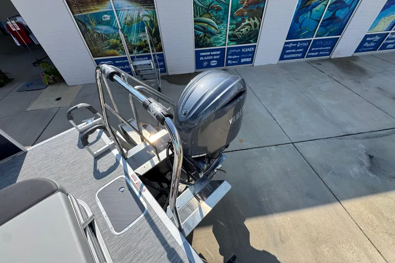 Slide: The Image of 2026 Bennington 22 SSB boat with Yamaha outboard motor, docked near marine-themed murals. - 37