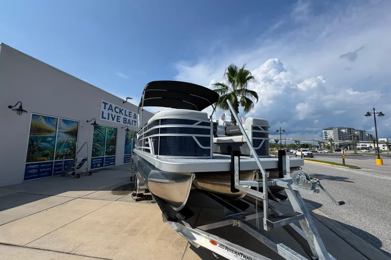Slide: The Image of 2026 Bennington 22 SSB pontoon boat displayed outside tackle shop under clear sky. - 7