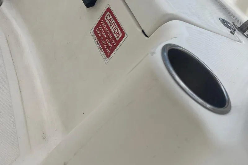 Slide: The Image of 2009 Scout 221 Winyah Bay boat interior with caution label and cup holder. - 11