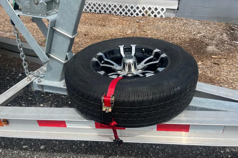 Slide: The Image of Trailer with spare tire secured by red strap on metal frame. Scout 221 Winyah Bay, 2009. - 15