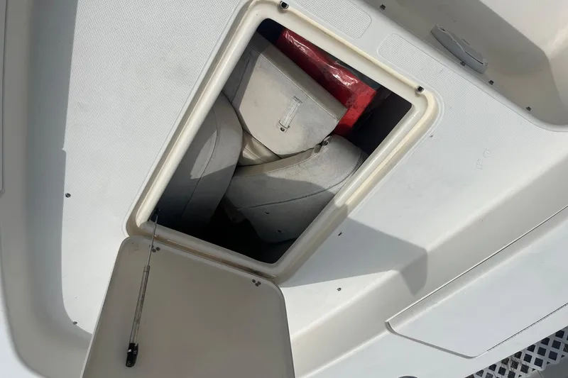 Slide: The Image of Open storage compartment on 2009 Scout 221 Winyah Bay boat, showing life jackets inside. - 4