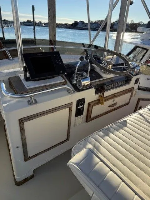 Slide: The Image of 1988 Blackfin 32 Flybridge helm with steering wheel, controls, and navigation equipment. - 11