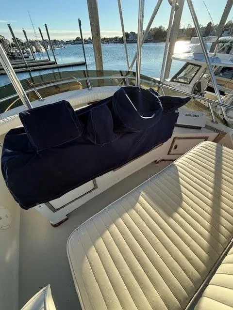 Slide: The Image of 1988 Blackfin 32 Flybridge boat interior with cushioned seating, docked at marina. - 13