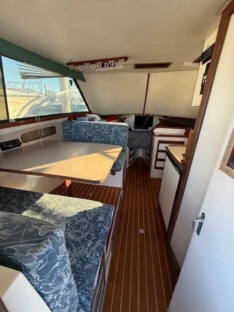 Slide: The Image of 1988 Blackfin 32 Flybridge interior with seating, table, and wood flooring. - 21