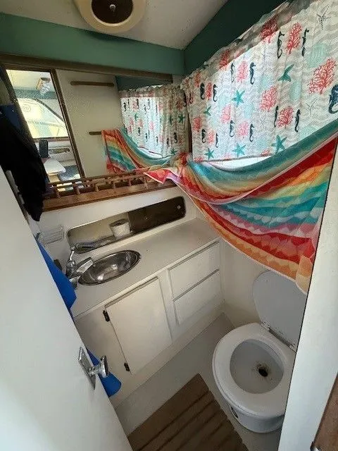 Slide: The Image of 1988 Blackfin 32 Flybridge bathroom with colorful curtains, sink, and toilet. - 26