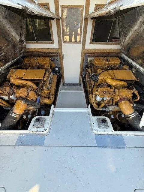 Slide: The Image of 1988 Blackfin 32 Flybridge engine compartment with dual engines, open hatches, and visible interior. - 28