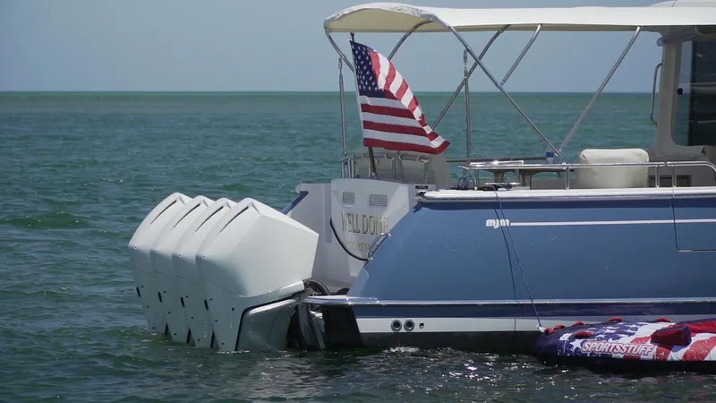 Slide: The Image of 2021 MJM 53z boat with multiple engines and American flag on open water. - 11