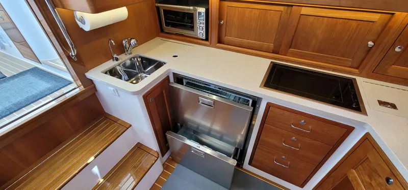 Slide: The Image of Modern galley kitchen in 2021 MJM 53z yacht with sink, stove, and dishwasher. - 43