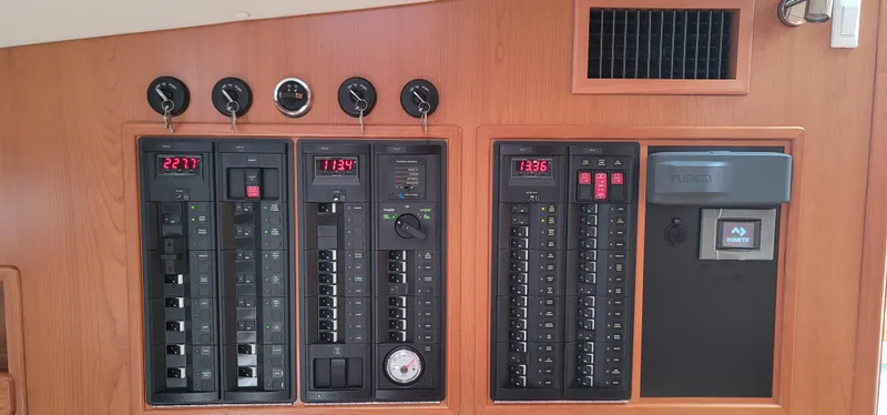 Slide: The Image of Electrical control panel on a 2021 MJM 53z boat, featuring multiple switches and gauges. - 46