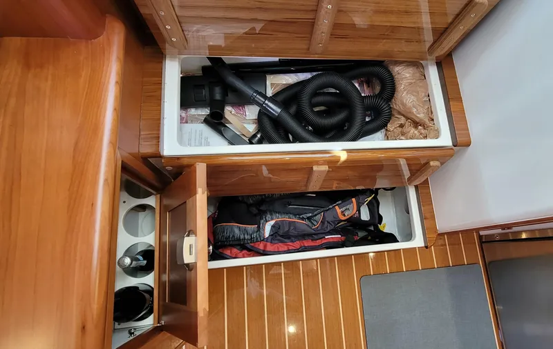 Slide: The Image of Interior storage compartments on a 2021 MJM 53z boat, featuring wooden finishes and organized spaces. - 47