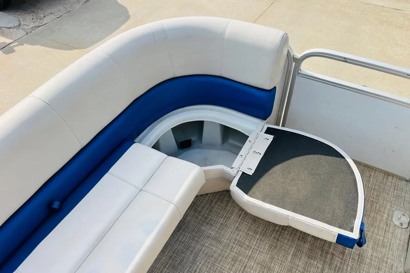 Slide: The Image of 2019 SunCatcher V322 RF boat interior with open storage compartments and cushioned seating. - 16