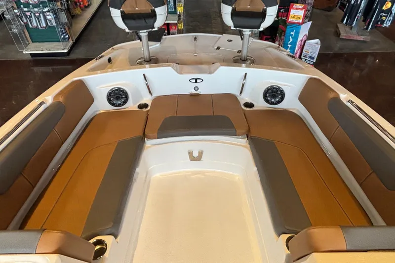 Slide: The Image of 2025 Tahoe 2150 boat interior with brown and gray seating, speakers, and cup holders. - 3
