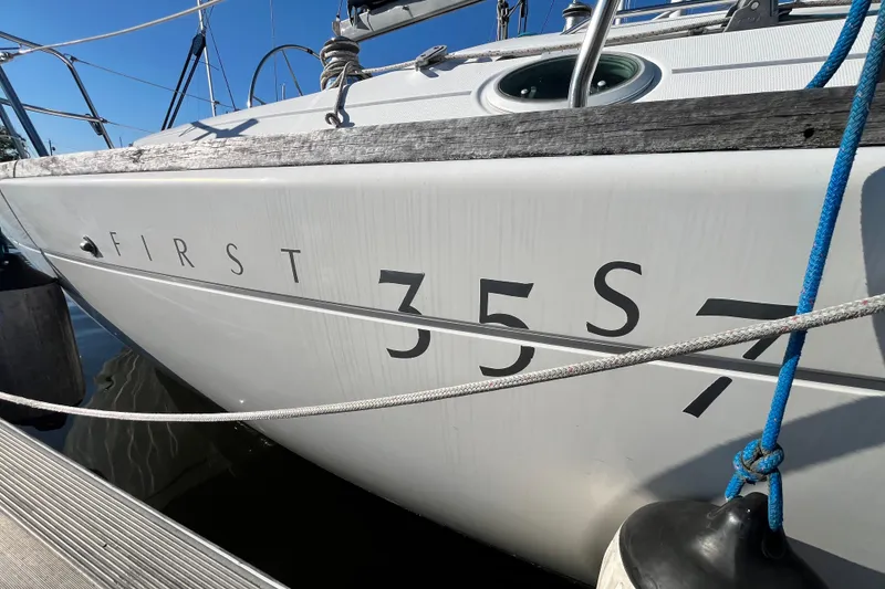Slide: The Image of 1994 Beneteau First 35s7 sailboat docked, showcasing model name on hull. - 2