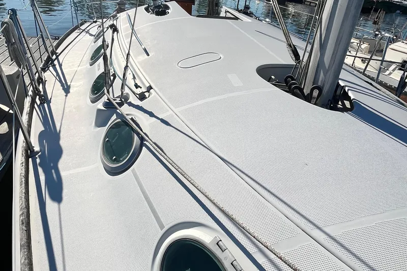Slide: The Image of Deck view of a 1994 Beneteau First 35s7 sailboat, featuring sleek design and portholes. - 22
