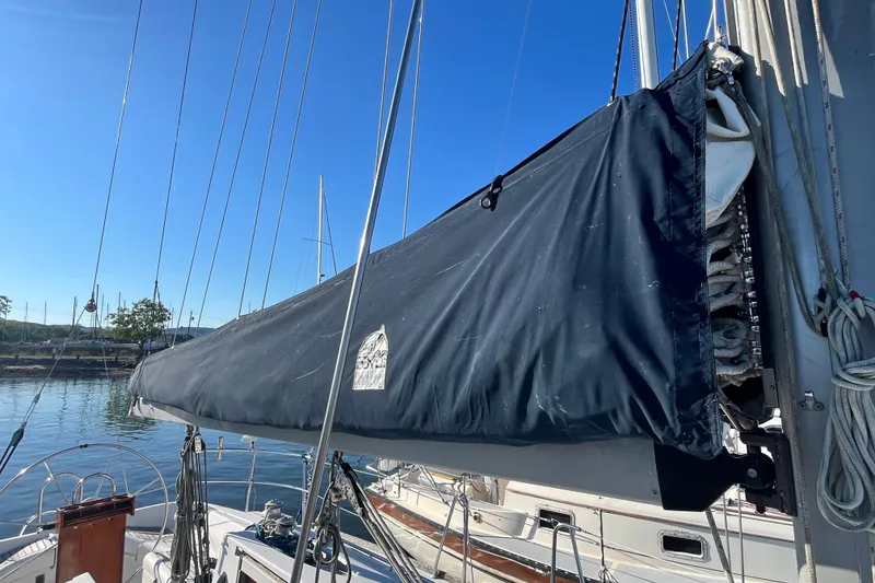 Slide: The Image of 1994 Beneteau First 35s7 sailboat with covered mainsail, docked under clear blue sky. - 23