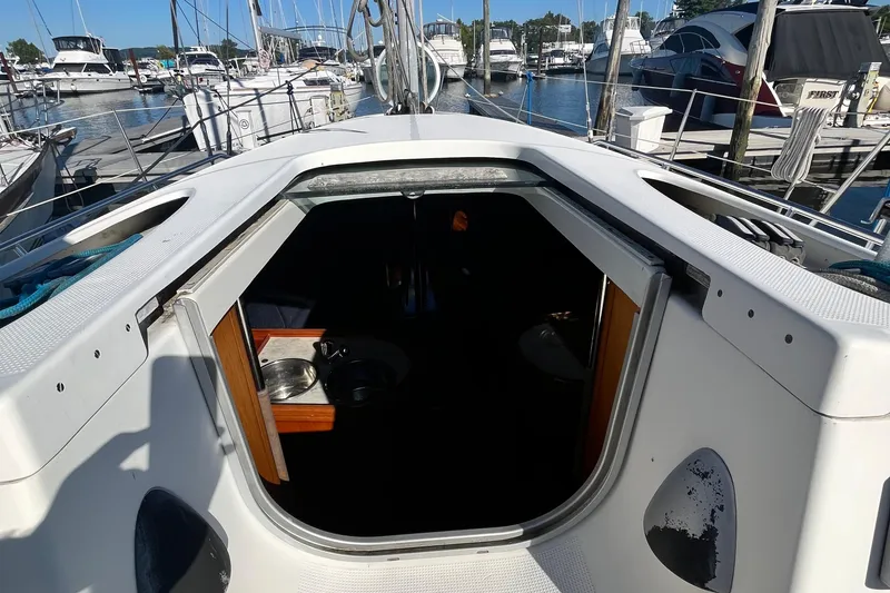 Slide: The Image of 1994 Beneteau First 35s7 sailboat cockpit view, marina background, open cabin entrance. - 30
