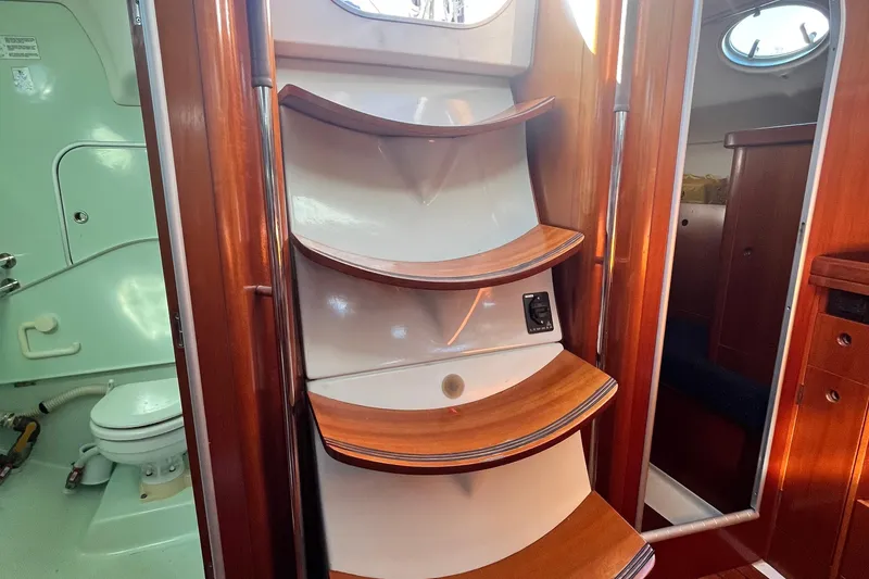 Slide: The Image of Interior of 1994 Beneteau First 35s7 sailboat with wooden steps and compact bathroom. - 32