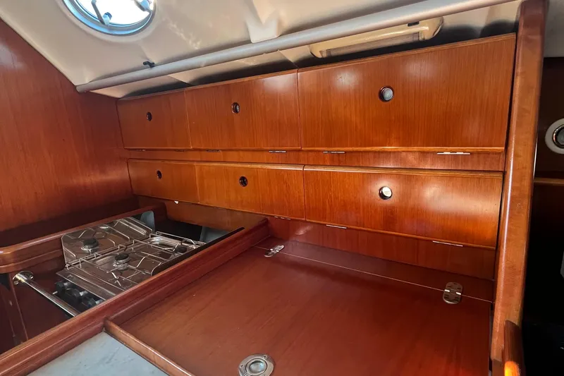 Slide: The Image of Interior of 1994 Beneteau First 35s7 yacht with wooden cabinetry and compact stove. - 37