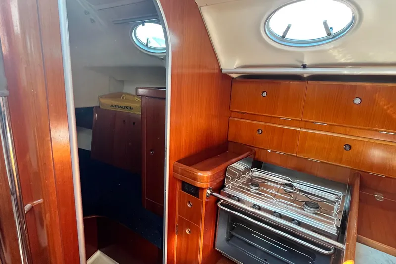 Slide: The Image of Interior of 1994 Beneteau First 35s7 yacht with wooden cabinetry and compact kitchen. - 39