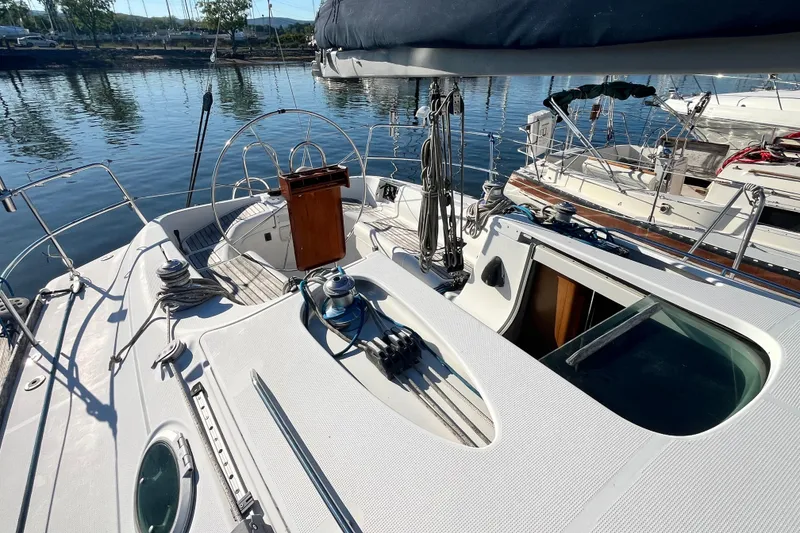 Slide: The Image of 1994 Beneteau First 35s7 sailboat cockpit with steering wheel and winches, docked at marina. - 4