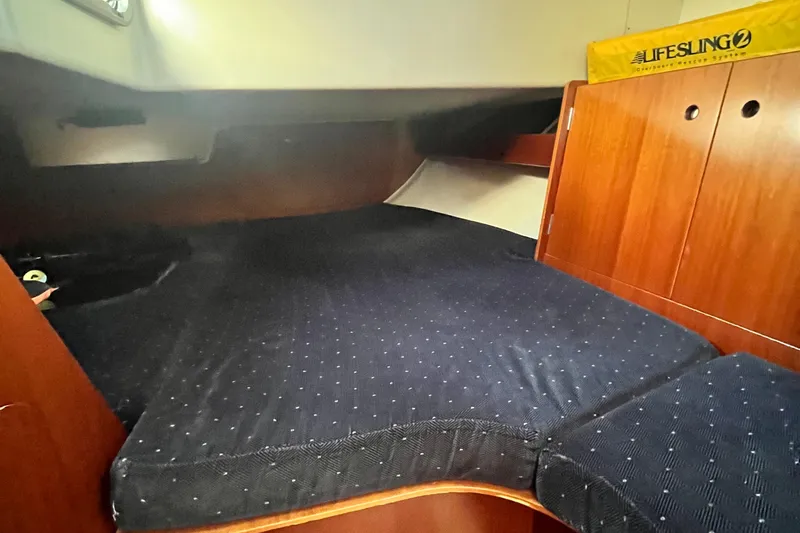 Slide: The Image of 1994 Beneteau First 35s7 cabin interior with dark bedding and wooden cabinetry. - 41