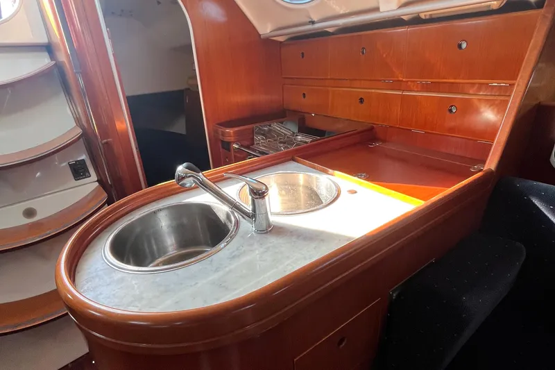 Slide: The Image of Interior of 1994 Beneteau First 35s7 yacht with wooden cabinetry and stainless steel sink. - 42