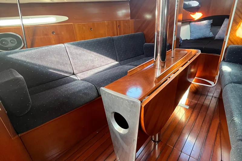 Slide: The Image of Interior of 1994 Beneteau First 35s7 yacht with wooden finish and cozy seating area. - 46
