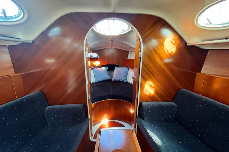 Slide: The Image of Interior of 1994 Beneteau First 35s7 sailboat with cozy seating and wooden finish. - 48