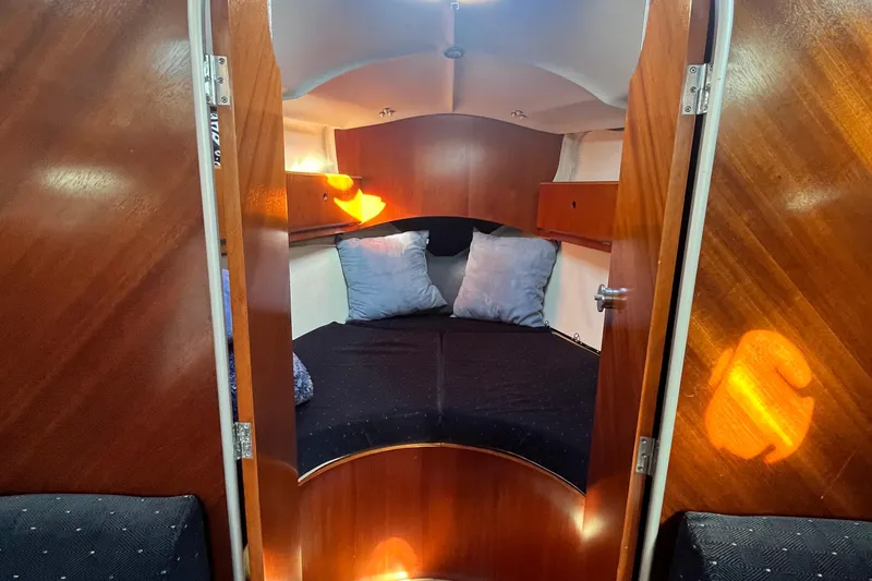 Slide: The Image of Cozy cabin interior of 1994 Beneteau First 35s7 sailboat with wooden finish and cushions. - 49