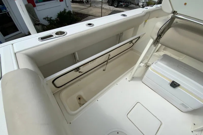 Slide: The Image of 2019 Boston Whaler 230 Outrage boat interior with storage compartment and cooler. - 17