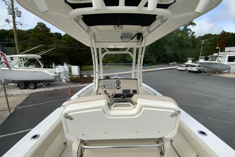 Slide: The Image of 2019 Boston Whaler 230 Outrage boat interior with helm and seating, parked at a marina. - 20