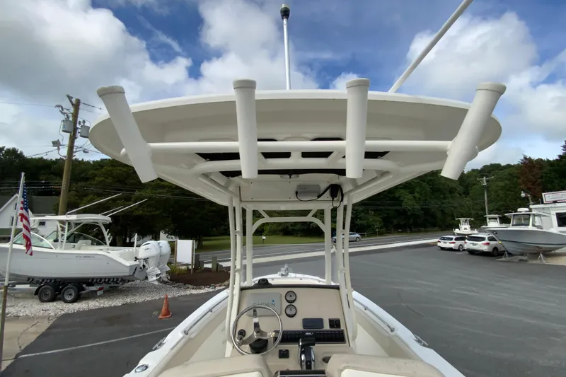 Slide: The Image of 2019 Boston Whaler 230 Outrage boat with T-top and console, parked outdoors. - 21