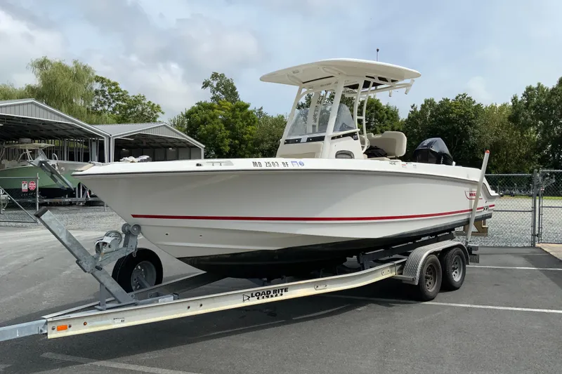 Slide: The Image of 2019 Boston Whaler 230 Outrage boat on trailer, parked outdoors near storage sheds. - 4